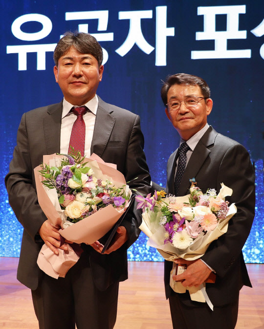 위니아대우와 위니아딤채가 '제14회 전자 IT의 날'을 맞아 각각 국무총리상과 산업통산부장관상을 수상했다. 김영찬 위니아딤채 제어개발담당(좌)와 박종문 위니아대우 품질경영실장(우측)이 기념 사진을 찍고 있다. <위니아딤채 제공>